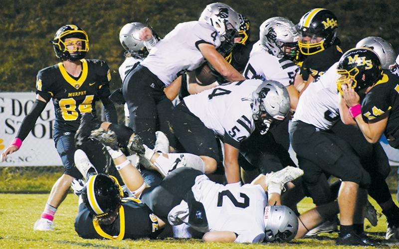 Dodging steady rainfall for much of the evening proved to be a challenge for both Robbinsville and Murphy on Friday. Here, Bulldogs quarterback Brady Grant could not get enough traction to escape Koleson Dooley (55) and Chase Calhoun (2), as the duo dropped Grant for a sack moments later.