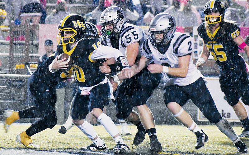 Dodging steady rainfall for much of the evening proved to be a challenge for both Robbinsville and Murphy on Friday. Here, Bulldogs quarterback Brady Grant could not get enough traction to escape Koleson Dooley (55) and Chase Calhoun (2), as the duo dropped Grant for a sack moments later. Photos by Kevin Hensley/sports@grahamstar.com