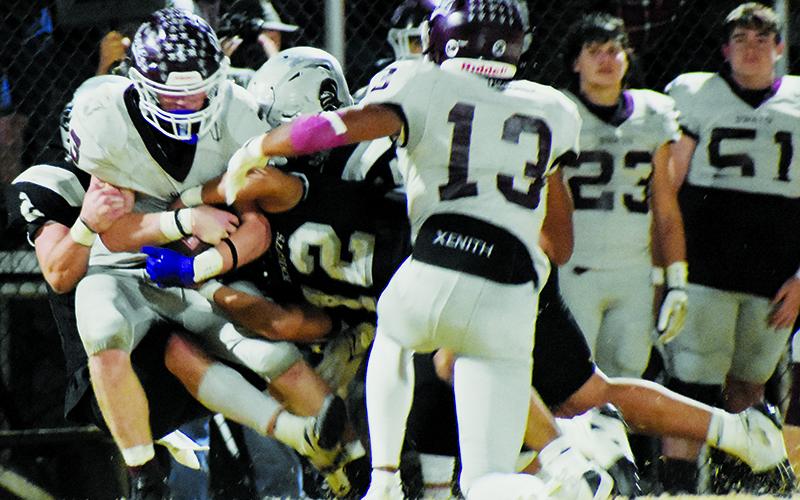 Chase Calhoun (2), Quinn Jumper (12) and Kellen Ensley drop Swain County's Joshua Collins for a loss during Robbinsville's 30-24, third-round playoff victory Friday. Photo by Fala Welch/The Graham Star
