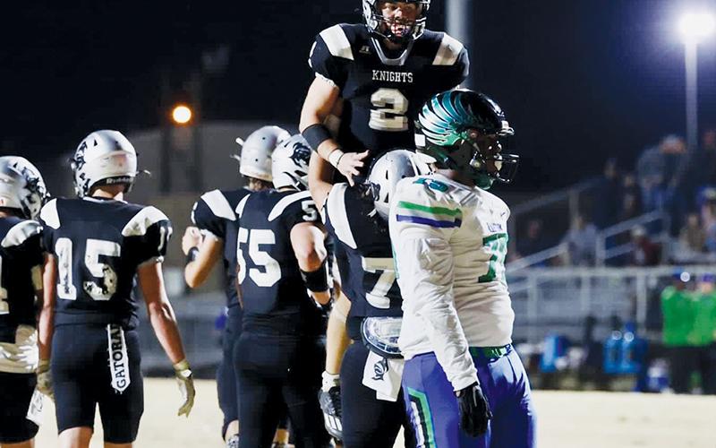 Senior Chase Calhoun (2) is hoisted in celebration by Tytan Teesateskie after his first of two touchdowns in the second quarter against Mountain Island Charter on Nov. 9.