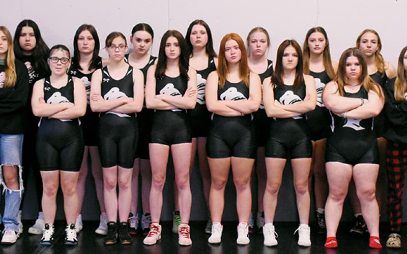 The 2023-24 Robbinsville Lady Knights varsity wrestling team. Names are listed from left. Front row: Nora Thomas, Koda Stinson, Anna Norris, Andrea Sheeks, Jayce Shuler, Velvet Carver, Hailey McLucas and Haley Burchfield. Back row: head coach Josh Winfrey, Alex Parton, Pacey Bradshaw, Kenzie Belk, Kaley Lofty, Kyla Jenkins,  Campbell Brooks, Alexis El-Khouri and Jennifer Guzman. Not pictured is assistant coach Sarah Orr. Photo by Kevin Hensley/sports@grahamstar.com
