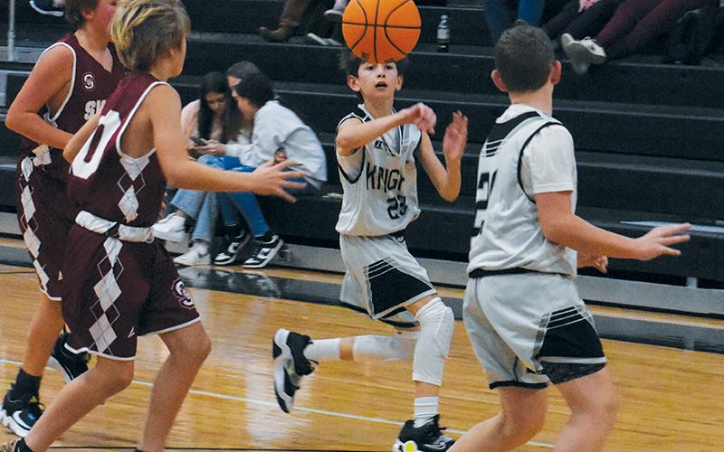 Carsan Snider (22) passes to Micah York late in Robbinsville Middle School’s 63-32, home victory over Swain County on Nov. 30. Photo by Kevin Hensley/sports@grahamstar.com