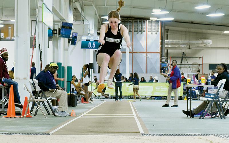 Lady Knights senior Zoie Shuler takes flight during the finals of Saturday’s state indoor track triple jump  competition. Shuler claimed her 4th triple jump state championship on her final attempt. Photos by Kevin Hensley/sports@grahamstar.com