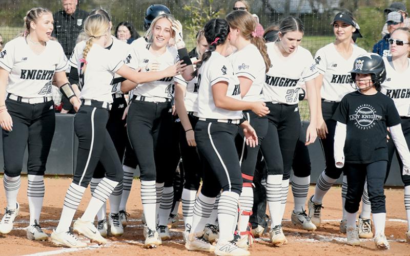 Nothing could erase the smile of Anna Williams (4), who was greeted by her exuberant teammates following her first varsity home run Monday against Enka. Photo by Jacquline Gayosso/The Graham Star