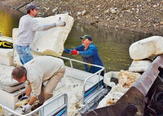 Brian Cable, Greg Davidson and Carl Ferguson (from left) unload just a small portion of trash collected during last weekend’s Fontana Lakes’ Clean-Up. Photo by Art Miller/amiller@grahamstar.com