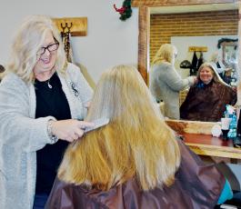 Gina Schuler, owner of Scissors Salon, shares a light-hearted moment with Mariann Miller on Tuesday. Photo by Art Miller/amiller@grahamstar.com