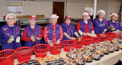 Susan Lyons, Bonnie Jeroslow, Cyndi Postell, Angie Colvin, Sandy Graves, Joyce Mitchell and Deborah Cheney (from left) stand prepared for assembly work during the Red Hat Lady Dragons’ annual Gifts from the Heart event Tuesday, Dec. 17. Photo by Art Miller/amiller@grahamstar.com
