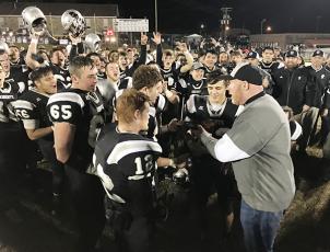 Robbinsville High School principal David Matheson (right) presents Black Knight players (from left) Carlos Wesley, Grady Garland, Kamron McGuire, Clayson Lane and Rylee Anderson with the 1A Western Regional Championship trophy, moments after a 28-14 win over Thomas Jefferson Classical Academy on Friday night. Photo by Kevin Hensley/editor@grahamstar.com