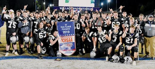 Members of the Robbinsville football team pose with their 1A state championship banner and trophy, after the Black Knights defeated the Northampton County Jaguars 45-14 at Duke University’s Wallace Wade Stadium. Photo by Kevin Hensley/editor@grahamstar.com