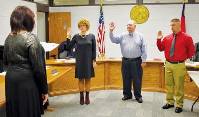Graham County Clerk of Court Tammy Holloway swears in (from left) newly-elected Board of Education member Pam Knott, incumbent chairman Rodney Nelson and new member Jonathan Allison. Photo by Charlie Benton/news@grahamstar.com