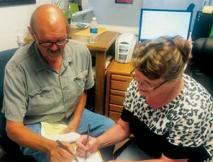 Sitting Robbinsville Mayor Steve Hooper (left) files for re-election with Graham County Board of Elections Director Teresa Garland on July 6. Hooper was the first candidate to file in Graham County for the 2021 general election. Photo by Tasha Holder/Graham County Board of Elections
