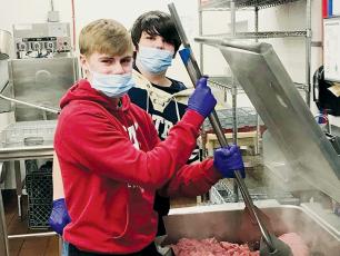Robbinsville Middle School’s Cooper Adams (front) and Isiac Collins were two of the students that helped feed homeless veterans in Asheville over the Christmas holiday.