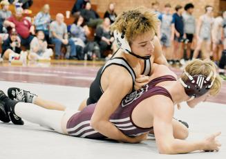 Robbinsville senior Jayden Nowell hooks the left arm of Swain County’s Owen Craig during the 132-pound bout of the Feb. 2 third round, dual-team championship match in Bryson City. Photo by Kevin Hensley/sports@grahamstar.com