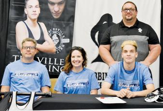 Black Knights senior Zane Lucksavage (seated, right) signed to wrestle for Colby Community College on May 3. Sitting with Lucksavage are father Phil (left) and mother Janelle. Standing in back is recently-retired Robbinsville head coach Todd Odom. Photo by Kevin Hensley/sports@grahamstar.com