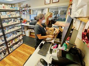 Pharmacist Dana Tanaka (left) and Pharmacy Technician Tonya Howell fill prescriptions at the Appalachian Mountain Community Health Center pharmacy on April 27.