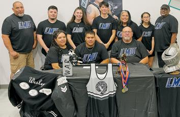 Carlos Wesley (seated, center) signed to wrestle at Lincoln Memorial University on Sunday. Surrounding Wesley are family and friends, including mother Scharlene Hardrick (seated, left) and Vincent Wesley, Bryan Wesley, Jasper Knighton, Staci Knighton, Seth Lawson, Jennifer Wesley, Briley Powers and Steven Hardrick (back row, from left). Photo courtesy of Todd Odom/Contributing Photographer