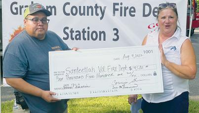 Town of Lake Santeetlah Mayor Connie Gross (right) presents a donation of $4,500 to Santeetlah Volunteer Fire Department Chief Brian Johnson at Aug. 4’s appreciation dinner. Photo by Randy Foster/news@grahamstar.com
