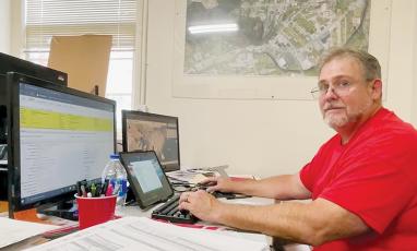 Chris Ferriss reviews revaluation data at his temporary desk at the Graham County Tax Assessor’s office in Robbinsville on Aug. 25. Ferriss is a real estate appraiser and tax consultant hired by the county to assist in its 2023 revaluation. Photo courtesy of Randy Foster/news@grahamstar.com