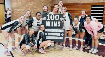 The Robbinsville Lady Knights surround head coach Kadey Phillips on Tuesday, moments after a 4-set victory at Swain County gave Phillips’ her 100th career win. All names are listed from left. Kneeling in front: Suri Watty and Delaney Brooms. Second row: Claire Barlow, Liz Carpenter, Tai Owle, manager Eden Orr, Kadey Phillips, Kensley Phillips, Desta Trammell, assistant coach Dede Brooms and Fala Welch. Standing in back is Aubrie Wachacha. Photos by Kevin Hensley/sports@grahamstar.com