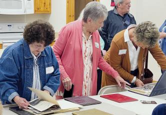 Patsy Owens Rogers (center) goes over high school yearbooks with Mountain View High School alumni Nahala Ayers Nichols (left) and Judy Williams Biddix during a reunion on Saturday. Rogers started the annual reunion in 2019 along with her late brother, Richard. Photo by Randy Foster/news@grahamstar.com