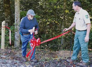 Graham County Commissioner Dale Wiggins (left) cuts the ribbon at a re-dedication ceremony of the  Santeetlah Lake Trail South on Sept. 27. Photos by Randy Foster/news@grahamstar.com