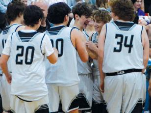Eli Lambert (second from right) is greeted cheerfully by his teammates Nov. 17, moments after he drained a 3-pointer at the final buzzer to stamp Robbinsville Middle School’s 45-27 win over Hayesville. Photos by Kevin Hensley/sports@grahamstar.com