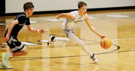 Senior point guard Brock Adams (right) breaks away from a North Buncombe defender in the first half of  Robbinsville’s double-overtime win over the Blackhawks on Friday. Photo by Miranda Buchanan/Robbinsville High School Yearbook