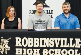 Haden Key signed to play football at Brevard College on May 3. Sitting with Key are his mother Joanna and coach Wren Millsaps. Photo by Kevin Hensley/sports@grahamstar.com