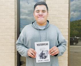 Robbinsville High School senior Skylar Jerkins shows off his debut novel, Yesteryear. Photo by Latresa Phillips/The Graham Star