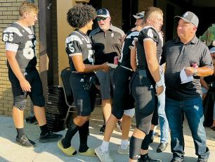 Prior to Friday’s season opener against East Surry, the Robbinsville Black Knights filed through a line to  personally thank local contractors and officials that helped complete the renovation of the home-seating area at Big Oaks Stadium in just 49 days. Players  pictured are Daegan Bird, Darion Ledbetter, Tillman Adams and Cuttler Adams (from left). Photo by Kevin Hensley/sports@grahamstar.com