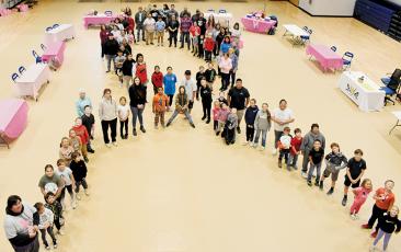 Participants of the Snowbird Breast Cancer 3K Walk create a ribbon shape inside the Jacob  Cornsilk Community Complex on Monday, as an ode to breast-cancer survivors and fighters. Photo by Ruby Annas/news@grahamstar.com