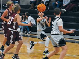 Carsan Snider (22) passes to Micah York late in Robbinsville Middle School’s 63-32, home victory over Swain County on Nov. 30. Photo by Kevin Hensley/sports@grahamstar.com