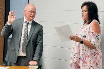 Andy Lynn (left) takes the oath of office from Graham County Clerk of Court Tammy Holloway on Tuesday, moments after the board of education accepted Lynn as the GOP’s nominee for filling a vacant seat. Photo by Kevin Hensley/editor@grahamstar.com